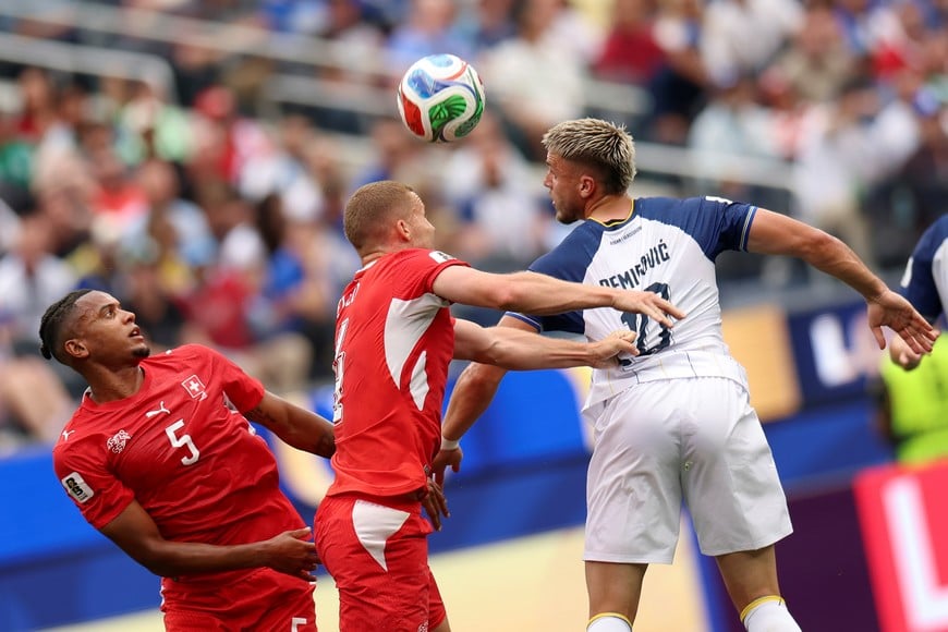 (260618) -- LOS ANGELES, 18 junio, 2026 (Xinhua) -- El jugador Ermedin Demirovic (d), de Bosnia y Herzegovina, salta para cabecear el balón durante el partido del Grupo B de la fase de grupos de la Copa Mundial de la FIFA 2026 ante Suiza, celebrado en el Estadio Los Angeles, en Los Angeles, Estados Unidos, el 18 de junio de 2026. (Xinhua/Bai Xuefei) (rtg) (da) (ah)