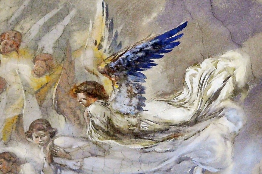 Primer plano del gran ángel de alas polícromas. En la superficie pintada se advierte el craquelado del soporte, otra señal de peligro.