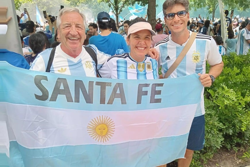El Tucu Volpatti junto a su hijo y su pareja, con la bandera de Santa Fe