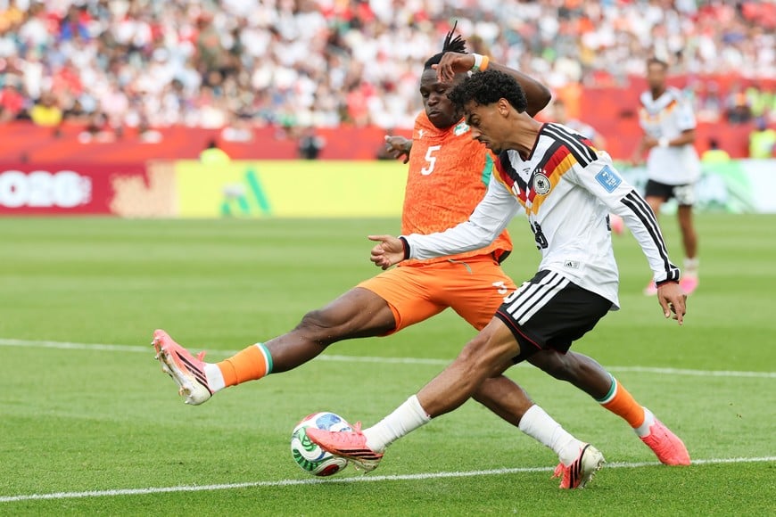 (260620) -- TORONTO, 20 junio, 2026 (Xinhua) -- El jugador Nathaniel Brown (d), de Alemania, disputa el balón con Wilfried Singo, de Cote d'Ivoire, durante el partido del Grupo E de la fase de grupos de la Copa Mundial de la FIFA 2026, celebrado en el Estadio Toronto, en Toronto, Canadá, el 20 de junio de 2026. (Xinhua/Zou Zheng) (rtg) (vf)