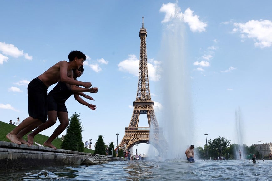 People cool off in the Trocadero Fountain next to the Eiffel Tower in Paris as temperatures rise during a heatwave affecting a large part of France, June 22, 2026. REUTERS/Abdul Saboor TPX IMAGES OF THE DAY