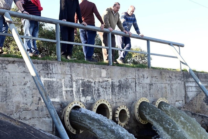 El intendente Poletti junto a funcionarios municipales, durante una lluvia importante, monitoreando el funcionamiento de una casabomba del oeste de la ciudad. Archivo.