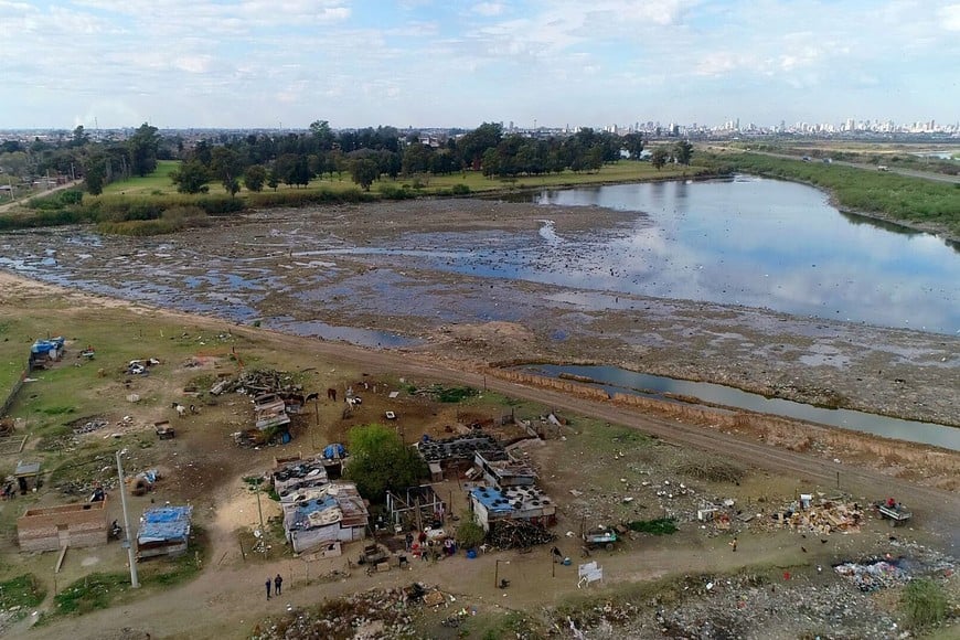 El reservorio del oeste en la zona de barrio Las Lomas, y allí cerca, un asentamiento. Fernando Nicola. Archivo.