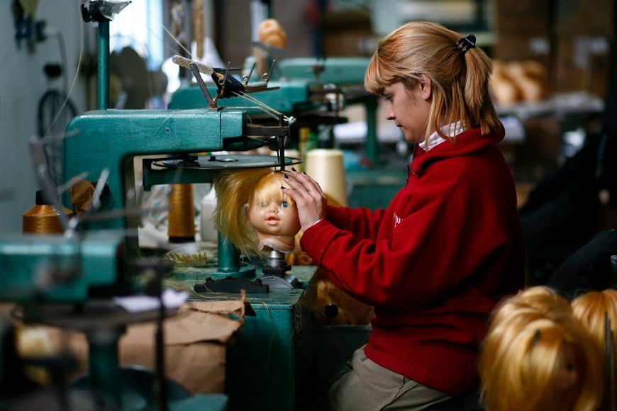 An employee sews a doll's hair to its head inside the toy factory owned by Norberto Garcia in Buenos Aires, July 28, 2014. Garcia was poised to launch a series of new toys this year after grafting hard for the past decade to rebuild his business following Argentina's 2001-2002 economic crash and debt default. Instead, he's hunkering down for a possible second default this Thursday, cutting investment plans and scaling back his targets. To match insight ARGENTINA-DEBT/ REUTERS/Marcos Brindicci (ARGENTINA - Tags: POLITICS BUSINESS EMPLOYMENT TPX IMAGES OF THE DAY) buenos aires fabrica de juguetes Turby Toy fabricacion de juguete juguetes crisis economica en el pais