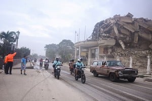 People drive past a collapsed building after an earthquake, in La Guaira, Venezuela, June 24, 2026. REUTERS/Maxwell Briceno