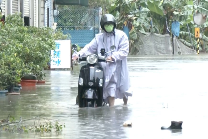 A man with a scooter moves in the floodwater during heavy rains caused by the nearby passing of typhoon Mekkhala, as it heads towards Japan, in Kaohsiung, Taiwan, June 25, 2026. CTS via REUTERS TV/via REUTERS    THIS IMAGE HAS BEEN SUPPLIED BY A THIRD PARTY. NO RESALES. NO ARCHIVES. TAIWAN OUT. NO COMMERCIAL OR EDITORIAL SALES IN TAIWAN. MANDATORY CREDIT.