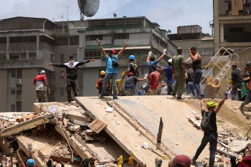 People gesture as they search for casualties amid the rubble of a collapsed building, in the aftermath of earthquakes in Caracas, Venezuela, June 25, 2026. REUTERS/Leonardo Fernandez Viloria