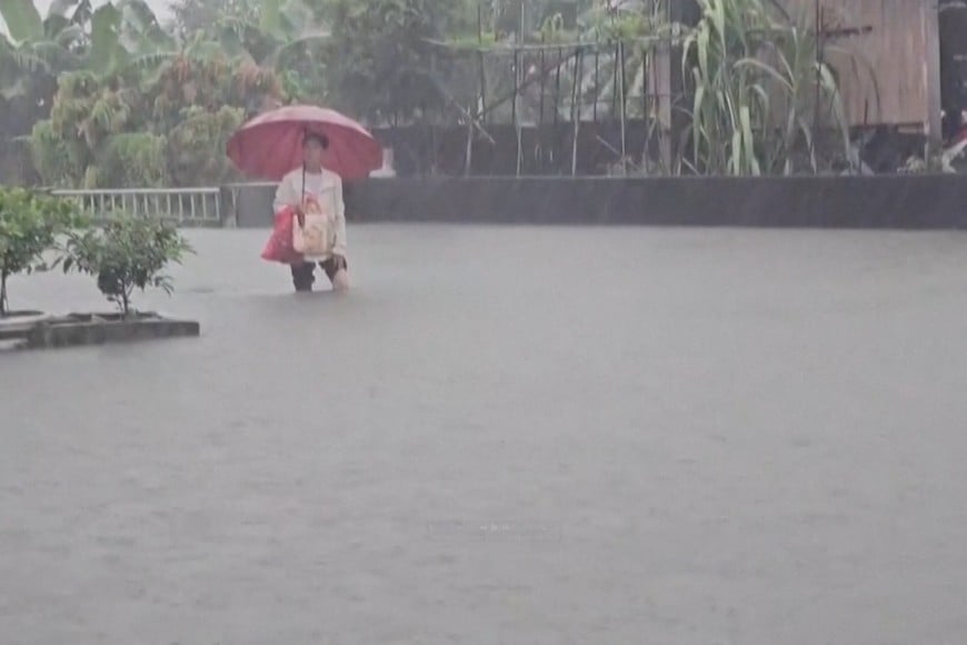 A man with an umbrella stands in the floodwater during heavy rains caused by the nearby passing of typhoon Mekkhala, as it heads towards Japan, in Pingtung, Taiwan, June 25, 2026, in this screen grab taken from a video. CTS via REUTERS TV/via REUTERS    THIS IMAGE HAS BEEN SUPPLIED BY A THIRD PARTY. NO RESALES. NO ARCHIVES. TAIWAN OUT. NO COMMERCIAL OR EDITORIAL SALES IN TAIWAN. MANDATORY CREDIT.