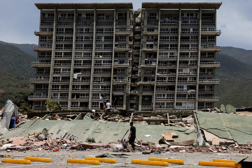 People inspect the rubble of a collapsed building after earthquakes hit the country, in La Guaira, Venezuela, June 25, 2026. REUTERS/Gaby Oraa      TPX IMAGES OF THE DAY