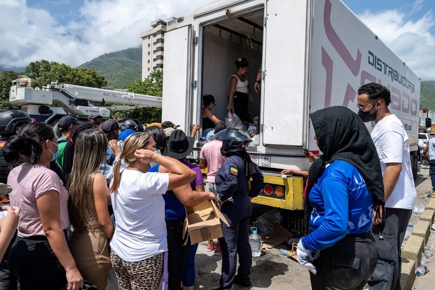 People queue to receive food and water donations, following earthquakes, in Caraballeda, La Guaira state, Venezuela, on June 27, 2026, MIGUEL MEDINA/Pool via REUTERS