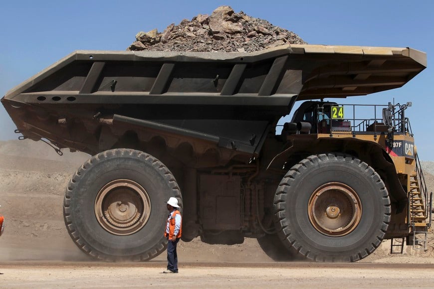 A mining truck loaded with rocks and minerals travels past a worker along a road at Chile's Esperanza copper mine near Calama town, about 1,650 km (1,025 miles) north of Santiago, March 30, 2011. Esperanza copper mine will be the only new major copper mine to come fully online this year, highlighting the deep supply deficit that has catapulted prices to record highs.  REUTERS/Ivan Alvarado (CHILE - Tags: BUSINESS ENERGY EMPLOYMENT) santiago de chile  trabajadores mina de cobre Esperanza mina de cobre precios record