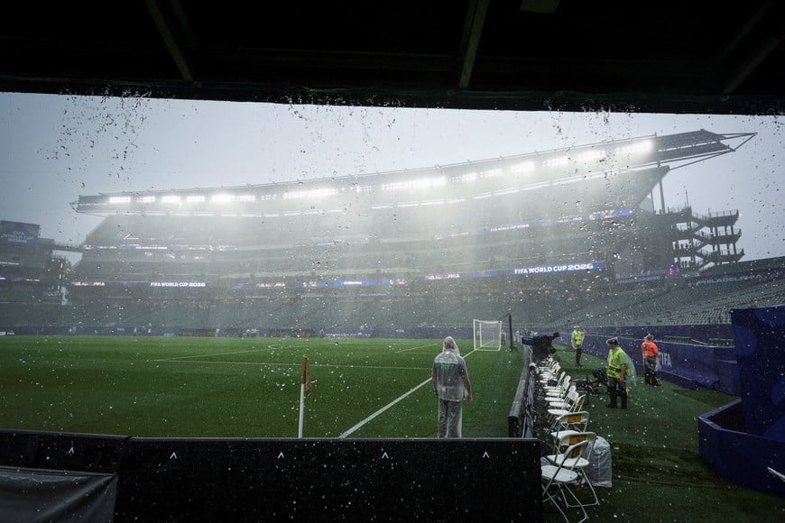 Soccer Football - FIFA World Cup 2026 - Group I - France v Iraq - Philadelphia Stadium, Philadelphia, Pennsylvania, U.S. - June 22, 2026 - A worker stands in the rain on the pitch during a delay due to severe weather REUTERS/Siphiwe Sibeko SEARCH "WORLD CUP HOST CITIES" FOR THIS STORY. SEARCH "WIDER IMAGE" FOR ALL STORIES.