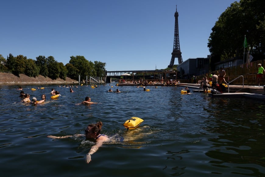 People swim in the River Seine at the Grenelle public bathing site, which is open to swimmers for the second year in the capital's historic waterway, with the Eiffel Tower in the background, in Paris, France, July 4, 2026. REUTERS/Tom Nicholson