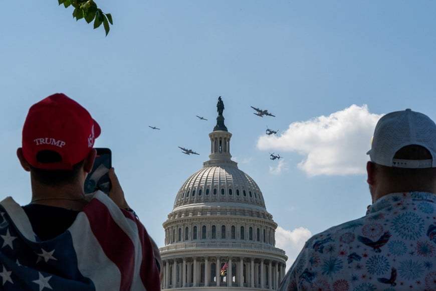 A supporter of U.S. President Donald Trump watches a U.S. Air Force fleet review fly over near the U.S. Capitol during Salute to America, marking the 250th anniversary of U.S. Independence in Washington, D.C., U.S., July 4, 2026. REUTERS/Elizabeth Frantz