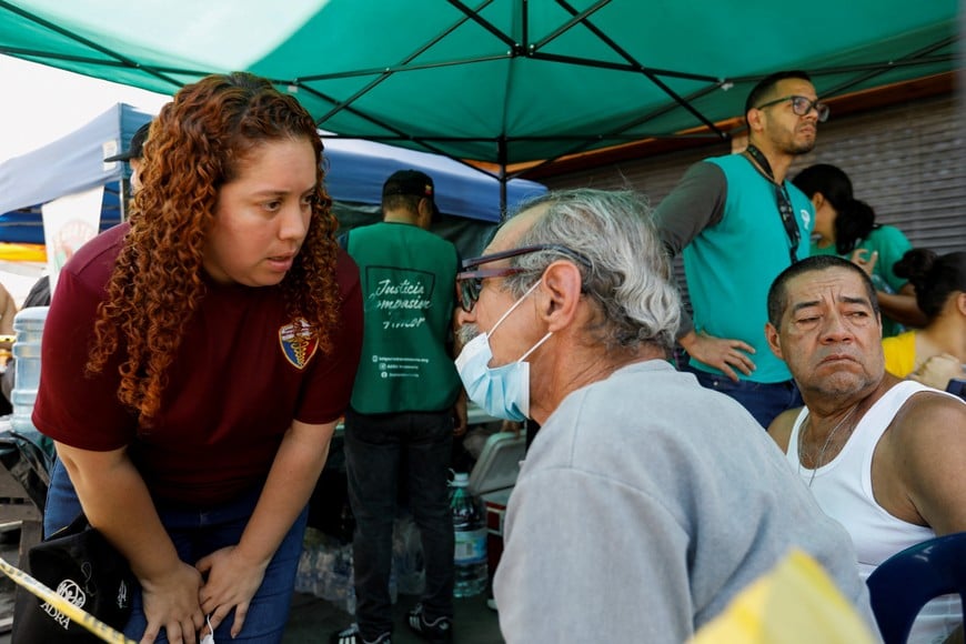 A volunteer talks to an elderly person before transferring them to a psychologist, a service offered to people affected by the earthquakes that hit the country, in Caracas, Venezuela, June 26, 2026. REUTERS/Fausto Torrealba