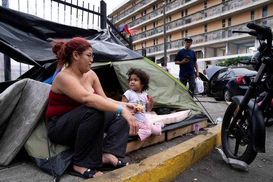 Displaced residents sit outside a tent after the housing complex where they live was damaged in the June 24 earthquakes and they were unable to return to their apartments, in Caracas, Venezuela, July 5, 2026. REUTERS/Marian Carrasquero