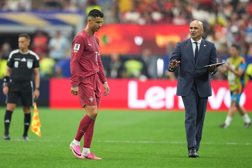 (260706) -- DALLAS, 6 julio, 2026 (Xinhua) -- El jugador Cristiano Ronaldo (i), de Portugal, y Roberto Martínez, director técnico de Portugal, reaccionan al término del partido de octavos de final de la Copa Mundial de la FIFA 2026 ante España, celebrado en el Estadio Dallas, en Dallas, Estados Unidos, el 6 de julio de 2026. (Xinhua/Wu Xiaoling) (ah) (vf)