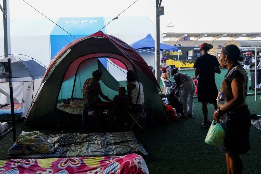 People gather near their tents at a makeshift shelter run by the United Nations (UN) at the Jose Maria Vargas Sports Complex, in the aftermath of the June 24 earthquakes, in La Guaira, Venezuela, July 7, 2026. REUTERS/Marian Carrasquero