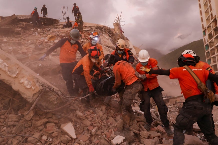 Rescuers carry a body bag of a victim amidst the rubble of a building, in the aftermath of the June 24 earthquakes, in La Guaira, Venezuela, July 8, 2026. REUTERS/Pablo Sanhueza