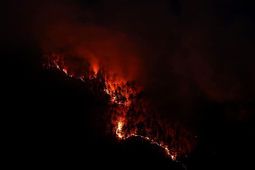 Flames rise from a wildfire that has been ravaging mountain vegetation for several days, during a heatwave affecting a large part of the country, at night near Die in the Drome department, France, July 9, 2026. REUTERS/Manon Cruz