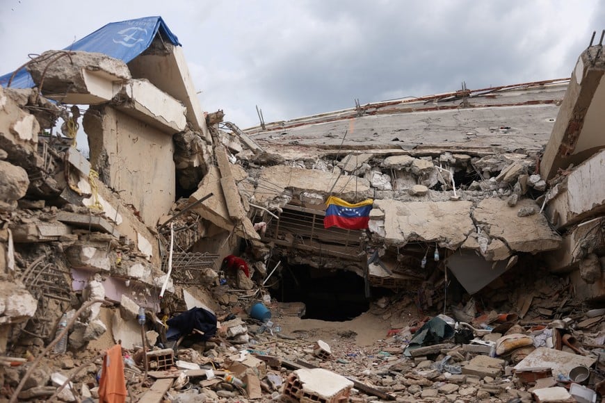A Venezuelan flag hangs surrounded by debris, in the aftermath of the June 24 earthquakes, in Caraballeda, La Guaira state, Venezuela, July 9, 2026. REUTERS/Leonardo Fernandez Viloria