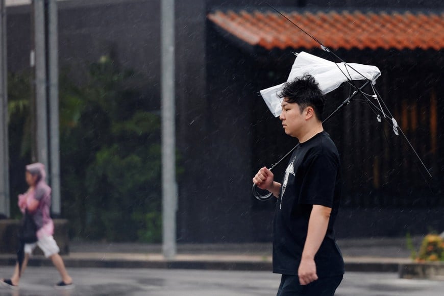 A man uses a broken umbrella in the rain after Typhoon Bavi passed through, in Ishigaki, Japan, July 11, 2026. REUTERS/Kim Kyung-Hoon