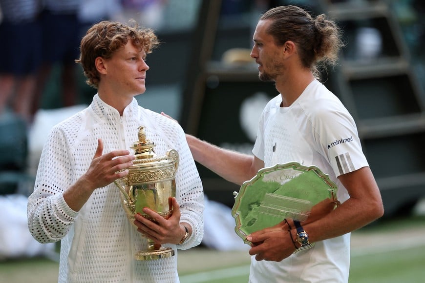 Tennis - Wimbledon - All England Lawn Tennis and Croquet Club, London, Britain - July 12, 2026
Italy's Jannik Sinner celebrates with the trophy as Germany's Alexander Zverev celebrates with the runner-up trophy after their final match REUTERS/Toby Melville