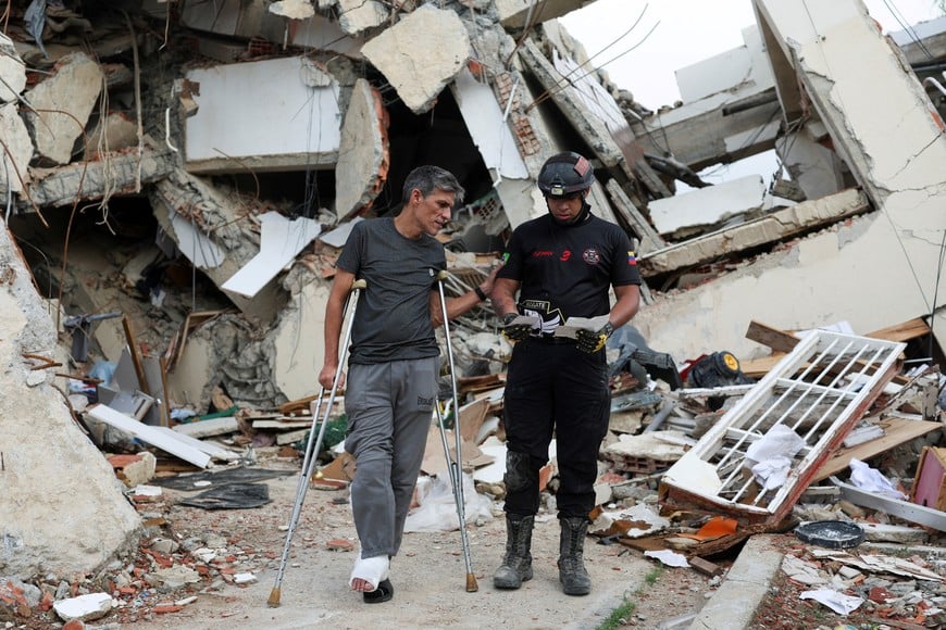 Francisco Soto, a survivor of the June 24 earthquakes, shows his rescuer Gabriel Echenique some documents he found in the rubble of his apartment, as he returns to look for documents and other valuables, in La Guaira, Venezuela July 12, 2026. REUTERS/Pablo Sanhueza