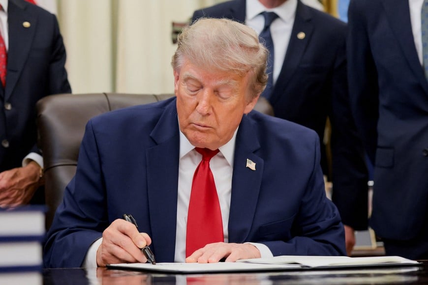 U.S. President Donald Trump signs an executive order related to Utah protected lands in the Oval Office at the White House in Washington, D.C., U.S., July 13, 2026. REUTERS/Kylie Cooper