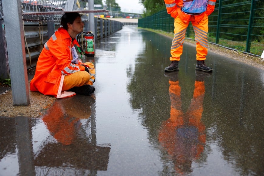 Formula One F1 - Belgian Grand Prix - Circuit de Spa-Francorchamps, Stavelot, Belgium - July 27, 2025
A steward shelters from the rain after the start of the race was delayed REUTERS/Stephanie Lecocq