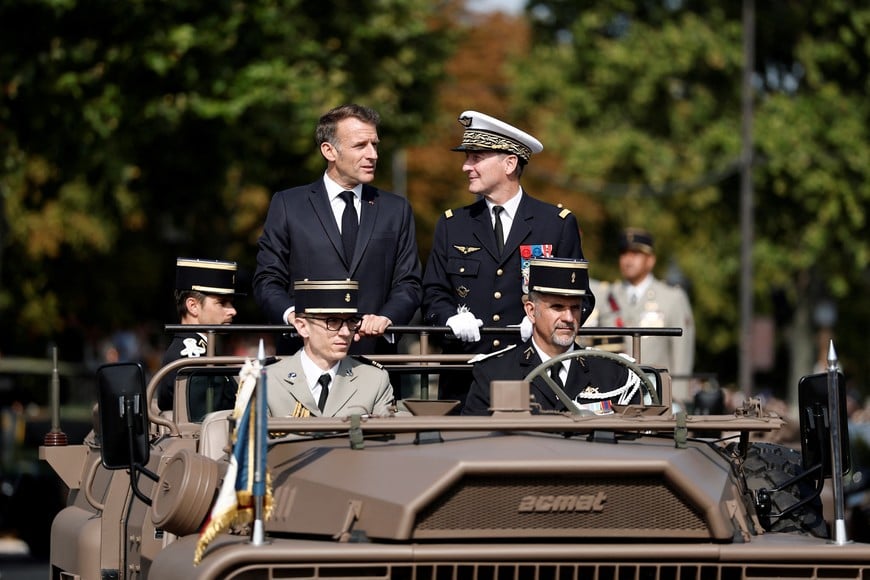 French President Emmanuel Macron stands in the command car with General Chief of Staff of the French Armed Forces Fabien Mandon during the annual Bastille Day military parade on the Champs-Elysees avenue in Paris, France, July 14, 2026. REUTERS/Benoit Tessier/Pool
