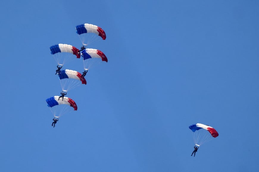 French army paratroopers, equipped with parachutes in the blue, white, and red colors of the French flag, attend a rehearsal prior to the start of the annual Bastille Day military parade on the Place de la Concorde in Paris, France, July 14, 2026. REUTERS/Tom Nicholson