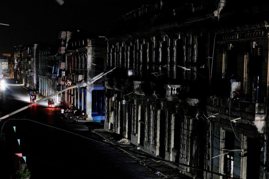 The facades of apartment buildings are illuminated by the headlights vehicles as Cuba's national power grid collapsed, marking the third major outage in nine days, in Havana, Cuba, July 14, 2026. REUTERS/Norlys Perez