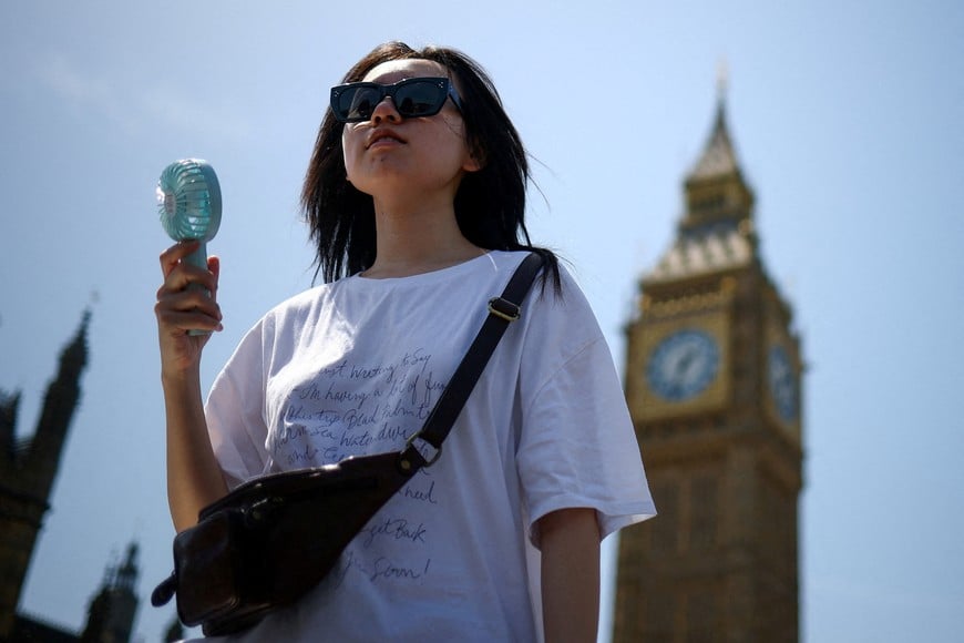 A woman uses a fan as she walks near the Houses of Parliament, amid hot weather in London, Britain, June 23, 2026. REUTERS/Guglielmo Mangiapane
TPX IMAGES OF THE DAY
