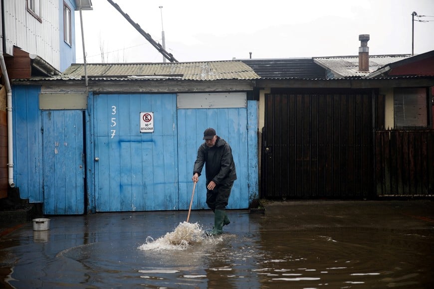 A local resident cleans the outside of his house of floodwater from the rain, which occurred during a weather front that led the Chilean authorities to declare a preventive state of emergency at the start of the week, in Arauco, Chile, July 16, 2026. REUTERS/Juan Gonzalez TPX IMAGES OF THE DAY