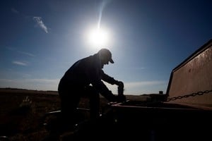 FILE PHOTO: An agricultural worker checks a seeder before sowing wheat on farmland in Comodoro Py, on the outskirts of Buenos Aires, Argentina June 21, 2022. REUTERS/Matias Baglietto/File Photo