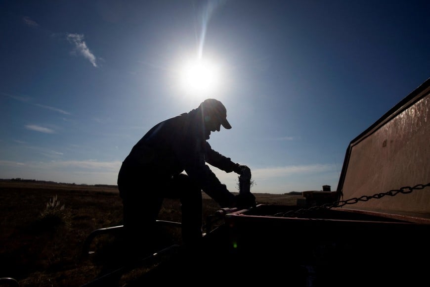 FILE PHOTO: An agricultural worker checks a seeder before sowing wheat on farmland in Comodoro Py, on the outskirts of Buenos Aires, Argentina June 21, 2022. REUTERS/Matias Baglietto/File Photo