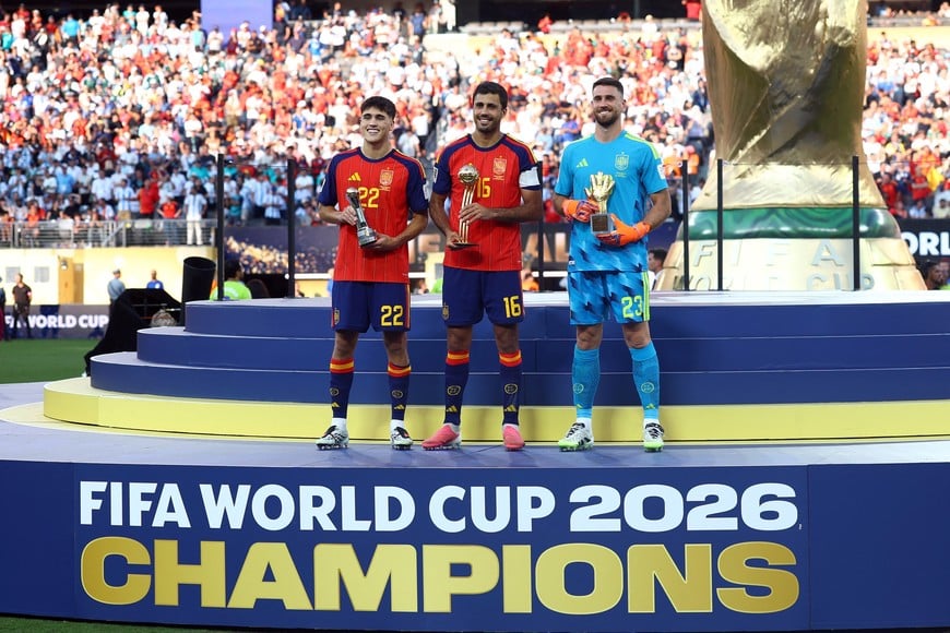 Soccer Football - FIFA World Cup 2026 - Final - Spain v Argentina - New York/New Jersey Stadium, East Rutherford, New Jersey, U.S. - July 19, 2026
Spain's Rodri celebrates on the podium after winning the Golden Ball with Golden Glove winner Unai Simon and FIFA Young Player winner Pau Cubarsi following winning the World Cup REUTERS/Hannah Mckay