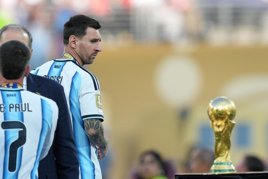(260720) -- NUEVA YORK, 20 julio, 2026 (Xinhua) -- Imagen del 19 de julio de 2026 del jugador Lionel Messi (d), de Argentina, observando el trofeo al término del partido final de la Copa Mundial de la FIFA 2026 ante España, celebrado en el Estadio Nueva York Nueva Jersey, en Nueva York, Estados Unidos. (Xinhua/Huang Zongzhi) (ah) (rtg) (ce)