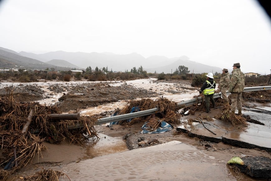 (260720) -- COQUIMBO, 20 julio, 2026 (Xinhua) -- Imagen del 19 de julio de 2026 de un trabajador municipal y miembros del Ejército chileno, observando un río desbordado durante un temporal, en la región de Coquimbo, Chile. El presidente de Chile, José Antonio Kast, decretó el lunes "estado de excepción de catástrofe" por calamidad pública en la región de Coquimbo y parte de Atacama, en el norte chileno, debido al sistema frontal de lluvias que afecta a 10 de las 16 regiones del país sudamericano. (Xinhua/Str) (jv) (ah) (rtg) (vf)