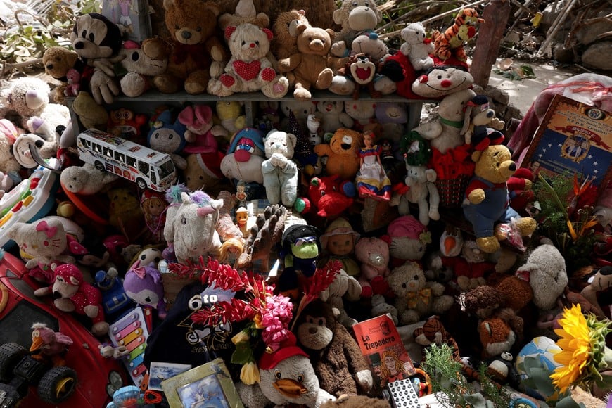 Toys and flowers are placed at a makeshift memorial created by family members of victims of the June 24 earthquakes in Tanaguarena, La Guaira, Venezuela, July 20, 2026. REUTERS/Gaby Oraa