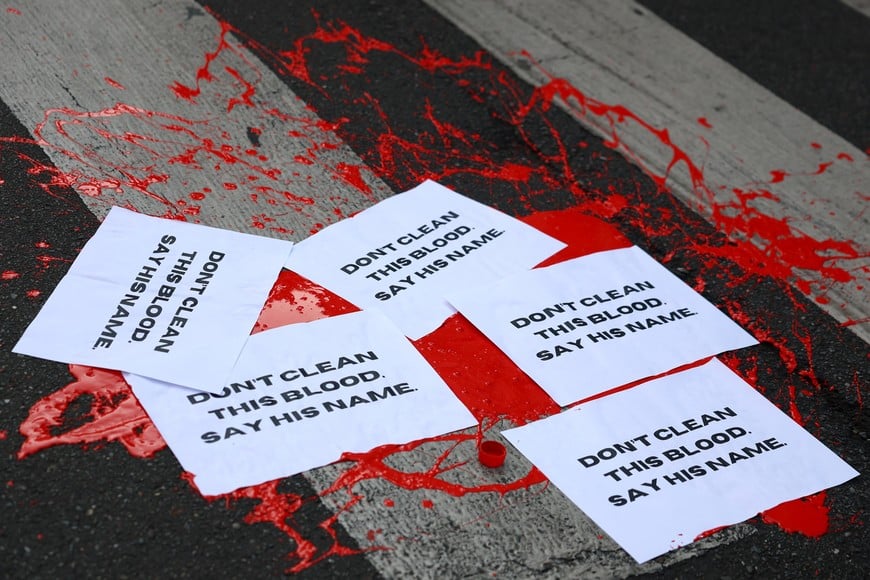 Papers reading "Don't clean this blood, say his name" lie on a street on top of red paint, during a protest following the death of Abderrahim Fakir, as police restrained him during an attempted detention in a street in Bologna, in Milan, Italy, July 21, 2026. REUTERS/Claudia Greco