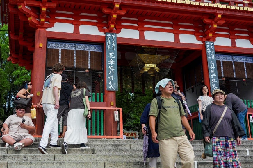 Visitors use portable fans to cool themselves at a shrine as the Japanese government issued a heatstroke alert in Tokyo and other prefectures due to a heatwave, in Kyoto, western Japan July 23, 2026. REUTERS/Fred Mery
