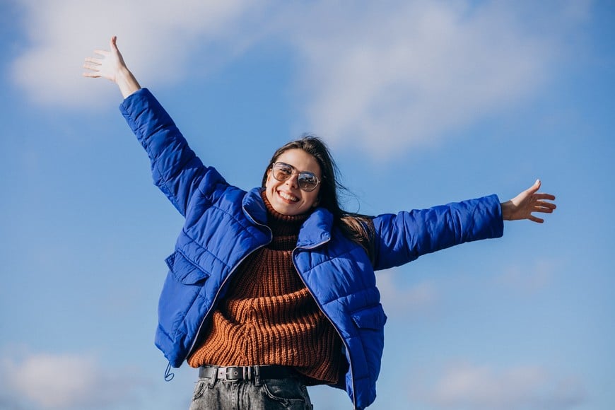 Young woman traveller in blue jacket by the lake
