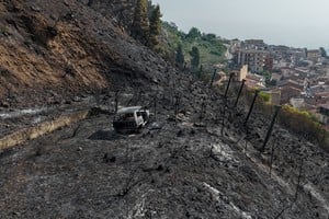 Una imagen tomada con un dron muestra un vehículo calcinado y vegetación quemada en una ladera tras un incendio forestal en Castronovo di Sicilia. REUTERS/Danilo Arnone