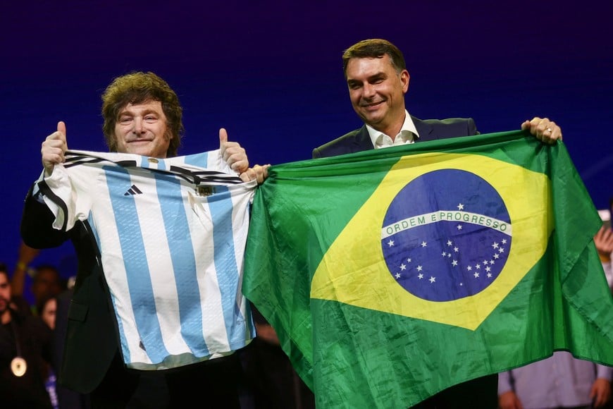 Argentine President Javier Milei and Brazilian Senator Flavio Bolsonaro, who is to be announced as  candidate for Brazil's presidential elections, hold an Argentine soccer team jersey and a Brazilian flag as they attend the national convention of the Liberal Party (PL) in Sao Paulo, Brazil, July 25, 2026. REUTERS/Jean Carniel     TPX IMAGES OF THE DAY