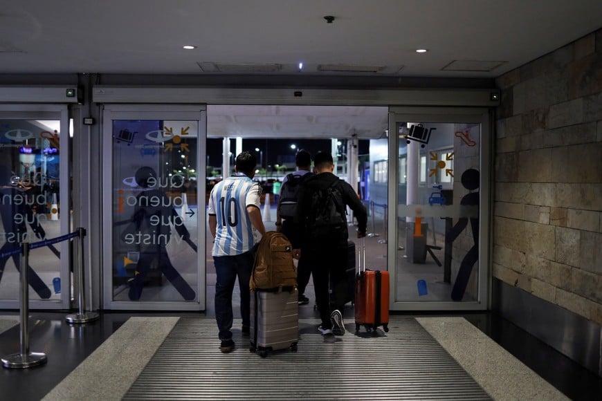 A man wearing Argentina's soccer star Lionel Messi's shirt walks into the Ezeiza international airport before taking the penultimate flight to Doha to attend Argentina's World Cup Final match, in Buenos Aires, Argentina December 16, 2022. REUTERS/Cristina Sille