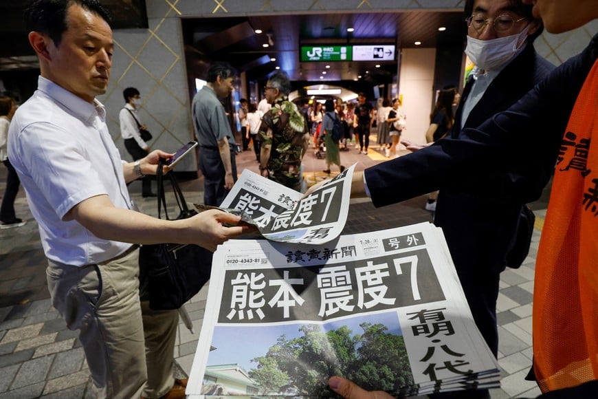 People receive extra editions of a newspaper reporting damages, after an earthquake with a preliminary magnitude of 7.1 struck Japan's southern Kumamoto Prefecture, in Tokyo, Japan, July 28, 2026. REUTERS/Manami Yamada?