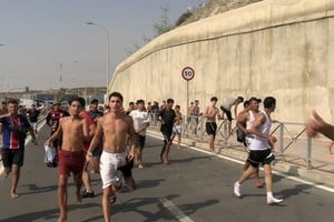 Migrants run and cheer as they cross on foot into the North African enclave of Ceuta from Morocco, after swimming over from the Moroccan side and overwhelming police at the city's breakwater, according to Spain's Guardia Civil, in Ceuta, Spain, July 30, 2026, in this screengrab obtained from a handout video. FARO TV via REUTERS

SPAIN OUT. NO COMMERCIAL OR EDITORIAL SALES IN SPAIN. THIS IMAGE HAS BEEN SUPPLIED BY A THIRD PARTY.