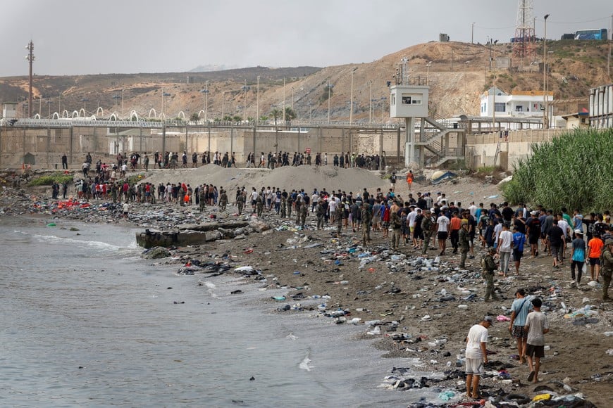 People walk towards the border with Morocco leaving Spain, amid mass crossings of migrants on foot and by sea from Morocco into Spanish territory, in Ceuta, Spain, July 31, 2026. REUTERS/Jon Nazca TPX IMAGES OF THE DAY